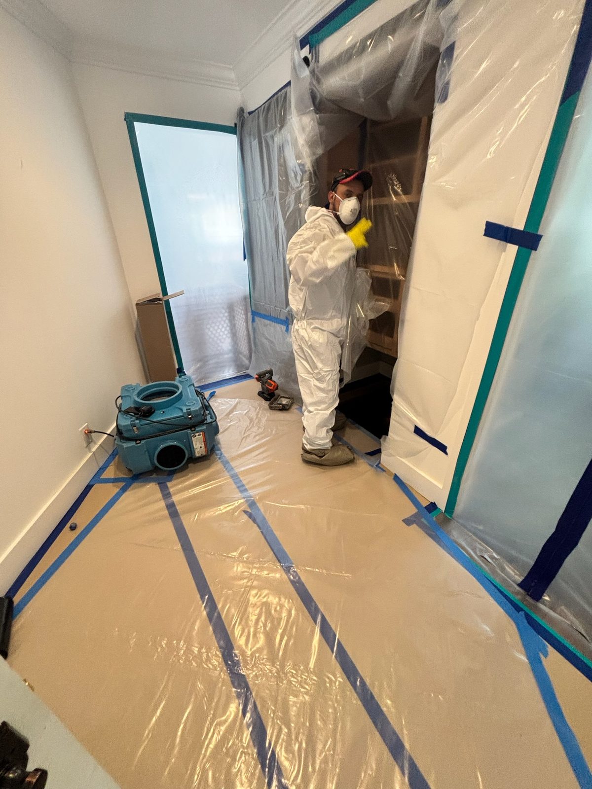 Mold remediation containment with technician in PPE